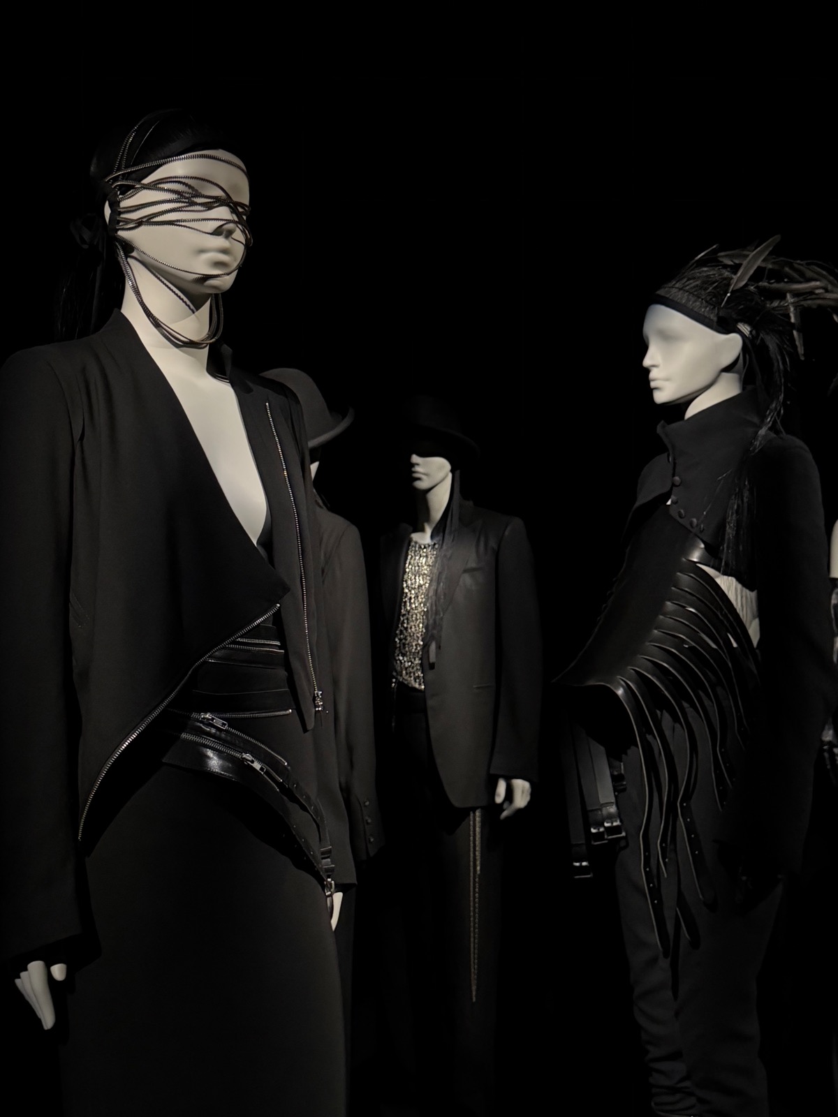 Ann Demeulemeester's room: black tailoring and wrapped faces in a sober, dark palette.