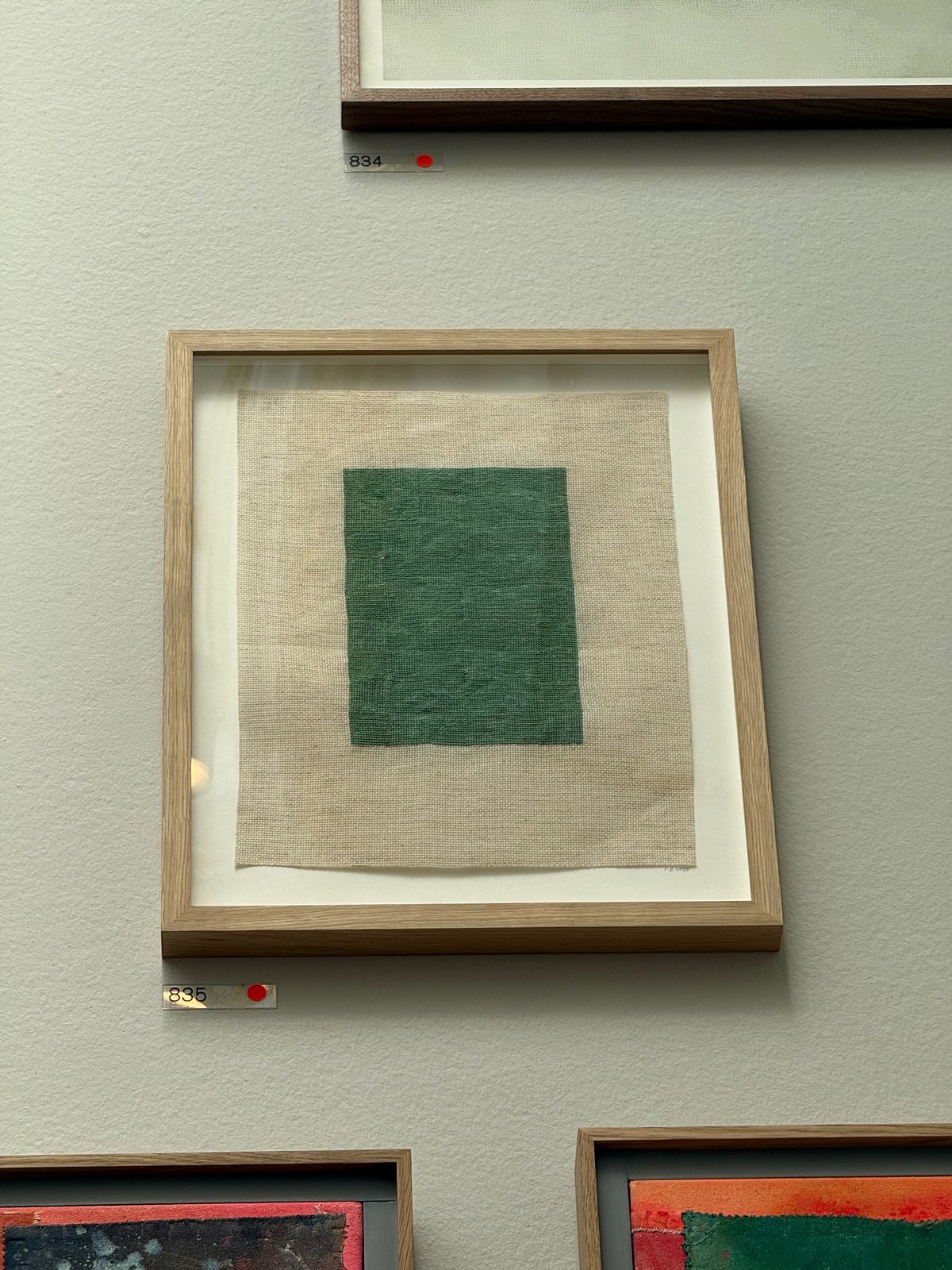 A green rectangle stitched in thread on raw unprimed canvas.