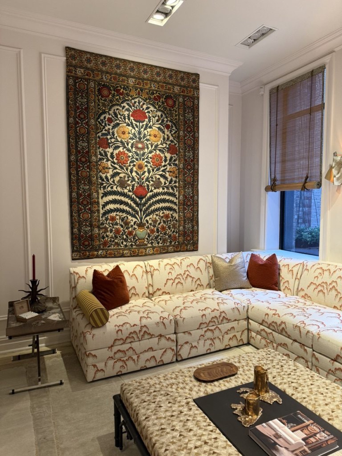 A room at The Invisible Collection's townhouse, an embroidered hanging over a patterned sectional.
