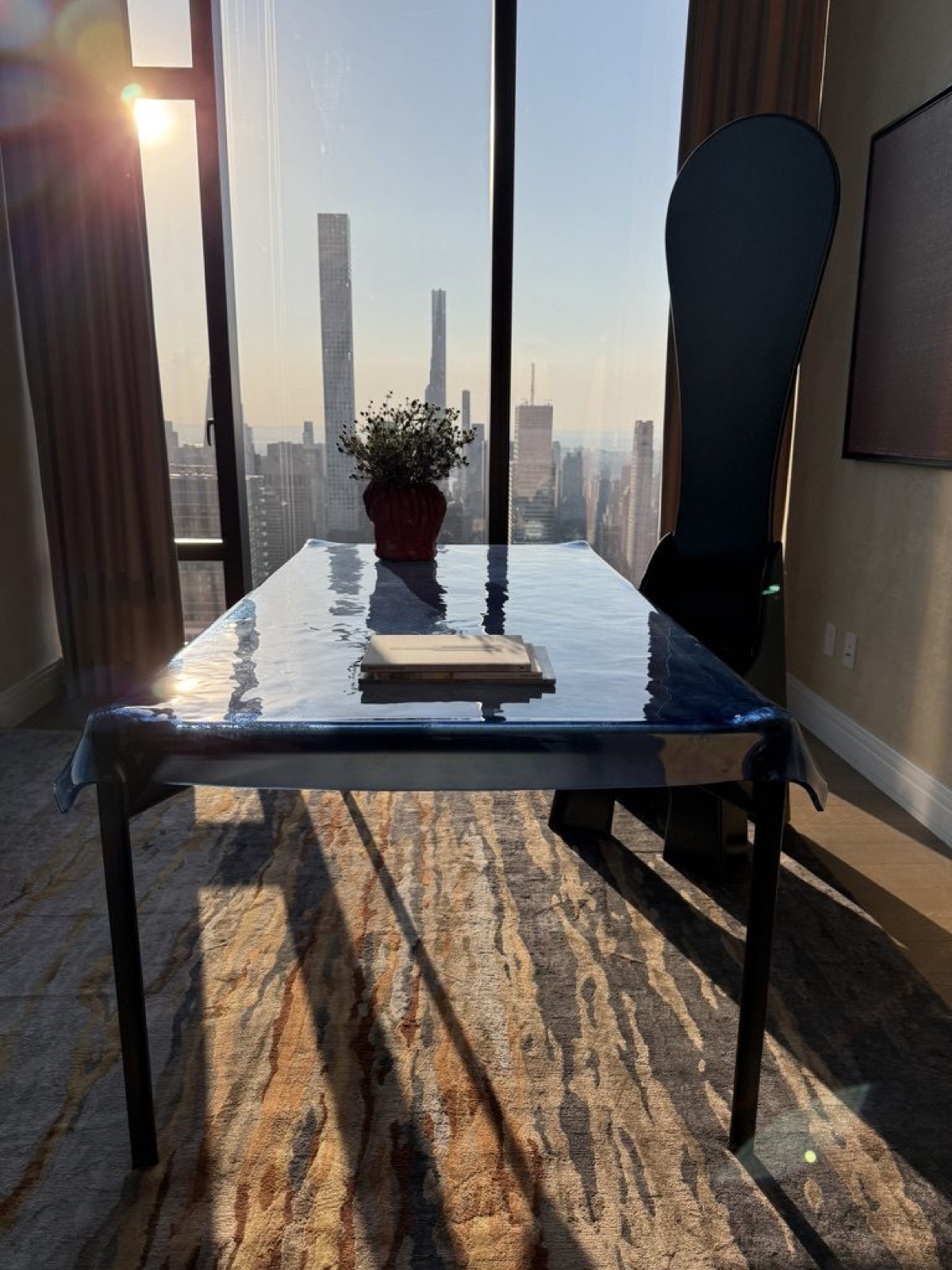 Philippe Starck's 'Illusion' table in dark blue glass over blackened brass, with a Mario Ceroli 'Fratina' chair.