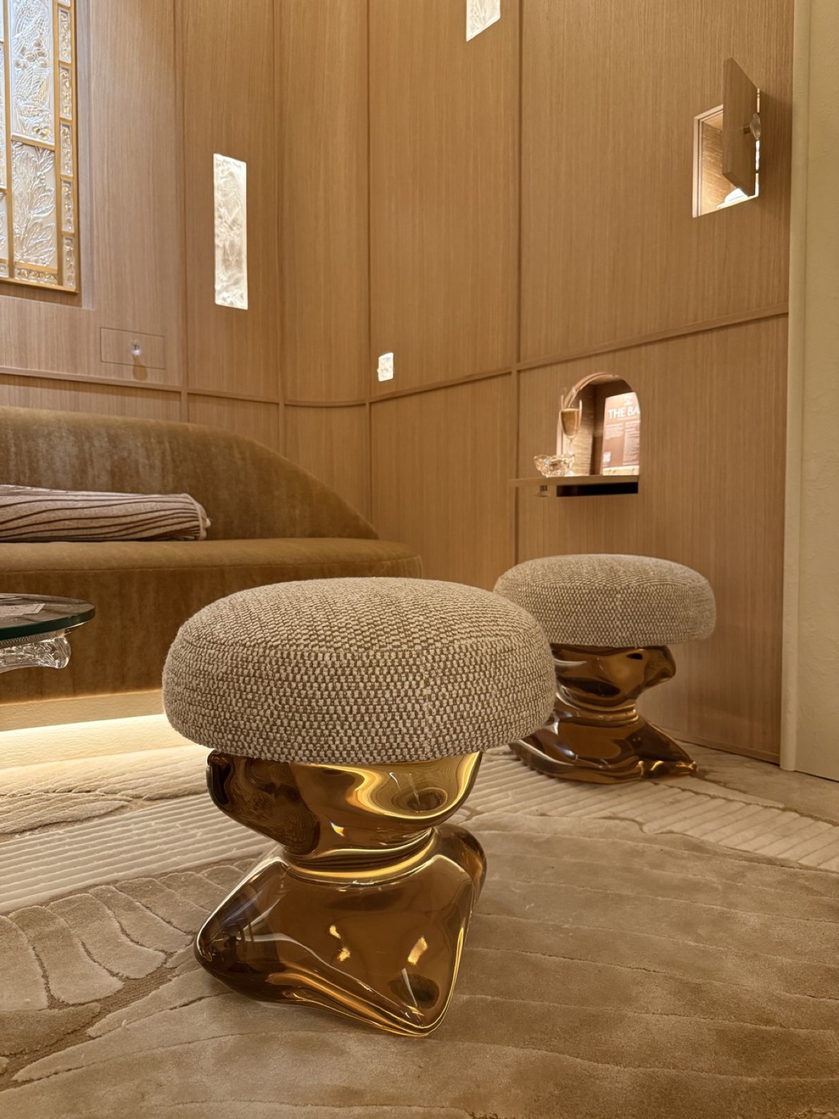 Two cream bouclé 'bust' pouffes on cast amber-resin bases.