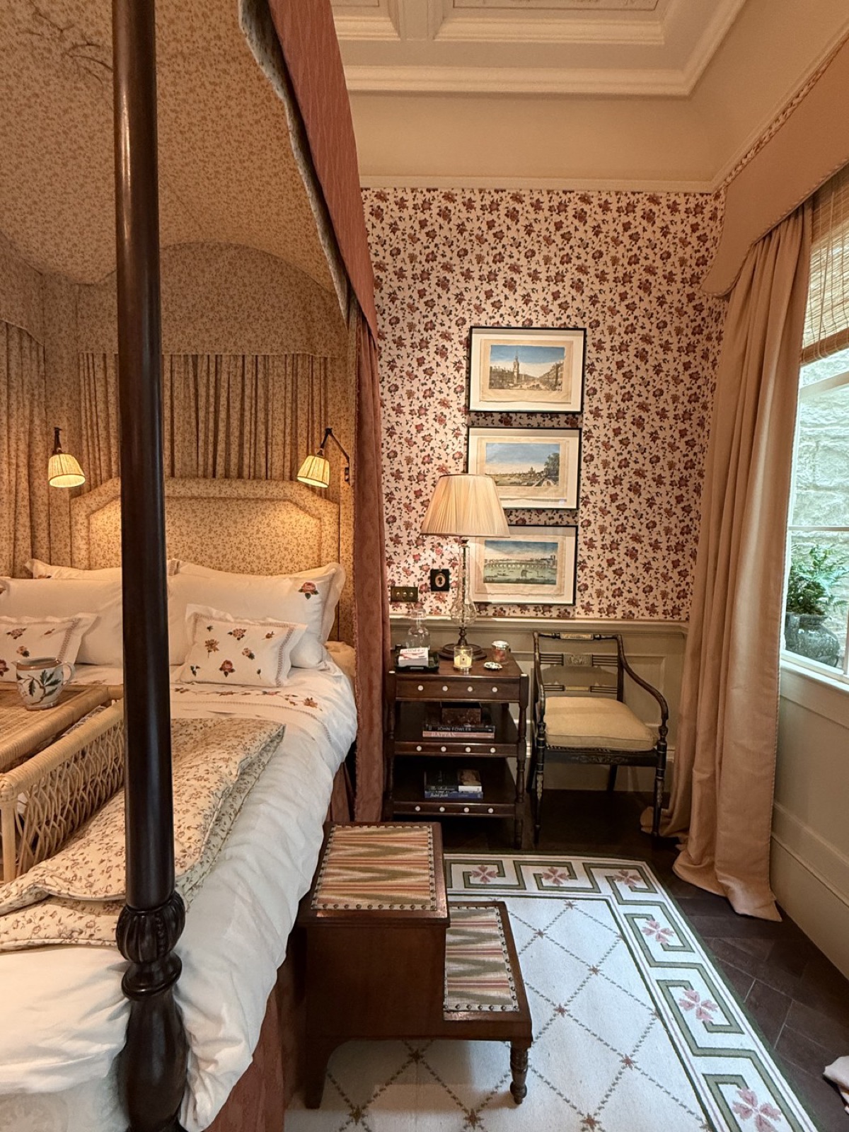 A pair of Regency ebonised armchairs beside a four-poster bed in Salvesen Graham's bedroom.